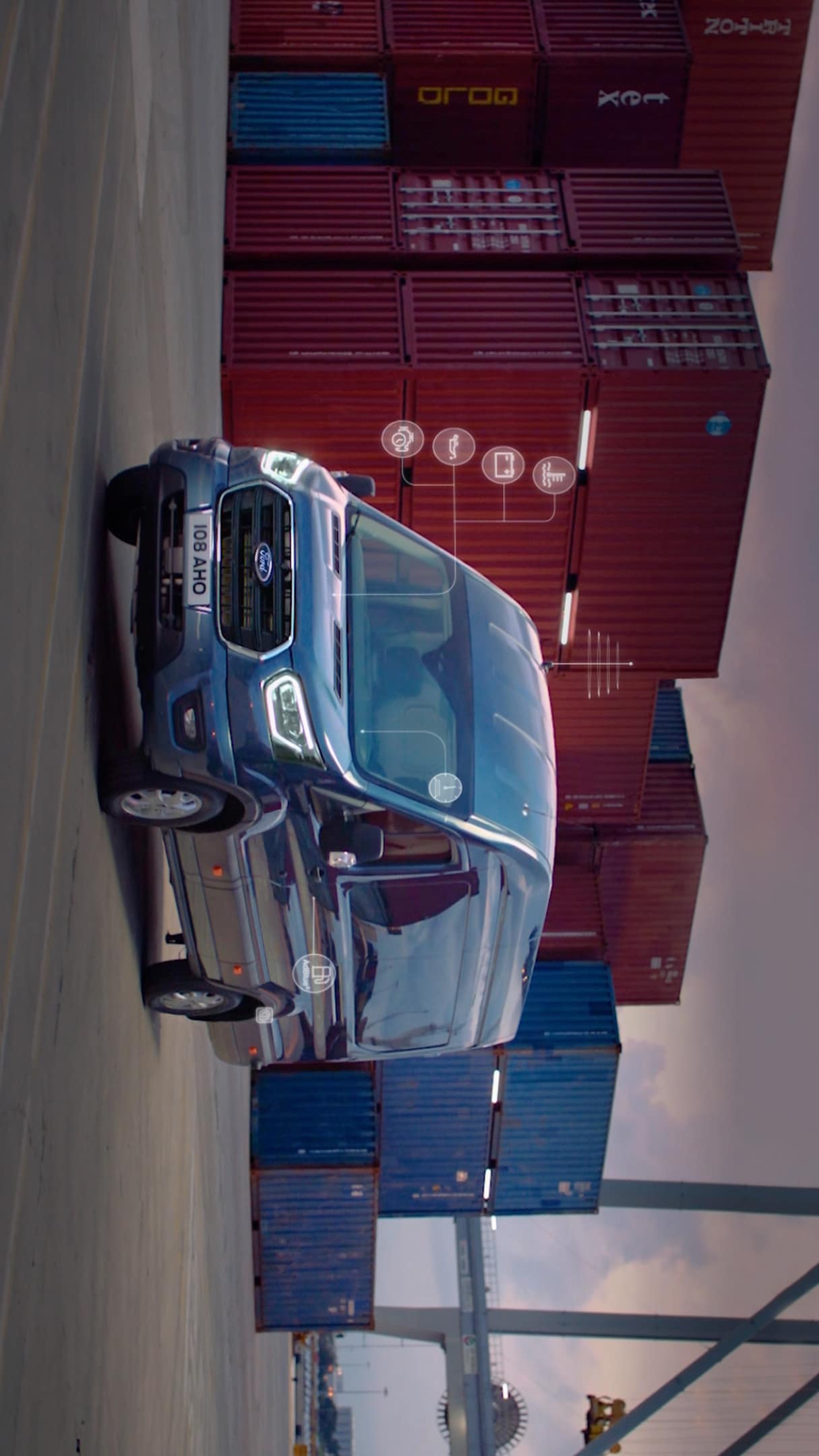 Blue Ford Transit by shipping containers